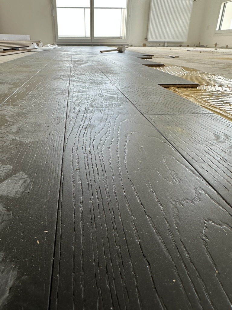 Vue de détail d’un revêtement de sol en cours de pose.